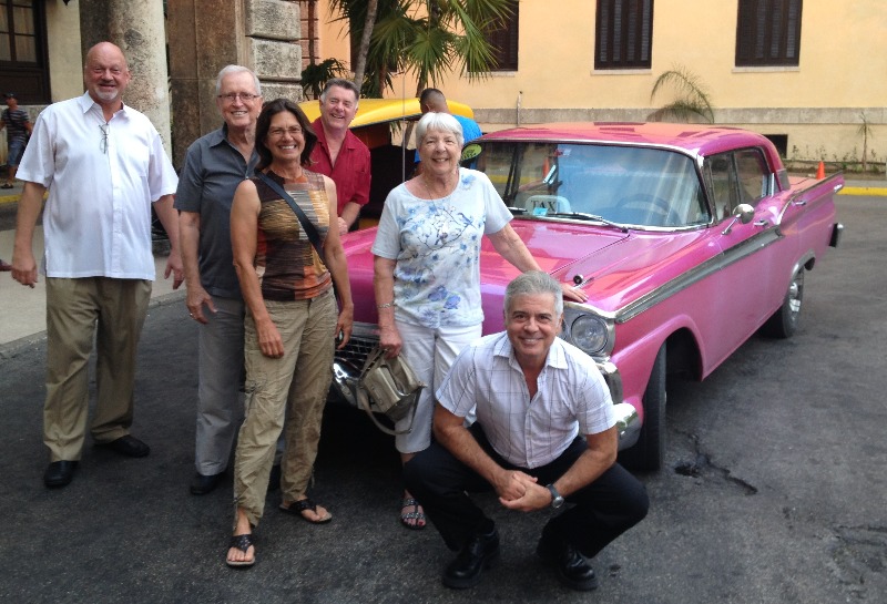 Doug mayberry with a group of travelers to cuba standing in front of a clasic car