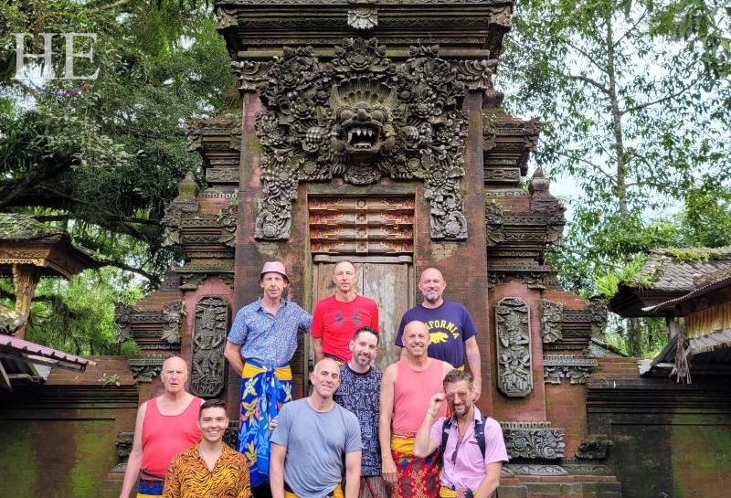 Zachary Moses and HE Travel group pose in Bali, all men are in sarongs. 