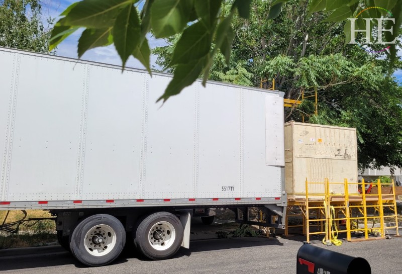 Tractor trailer backed up to a homemade loading deck made of scaffolding